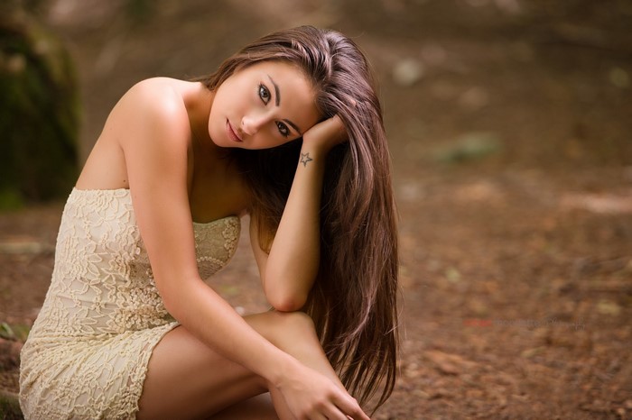Woman with long brown hair wearing a lace dress