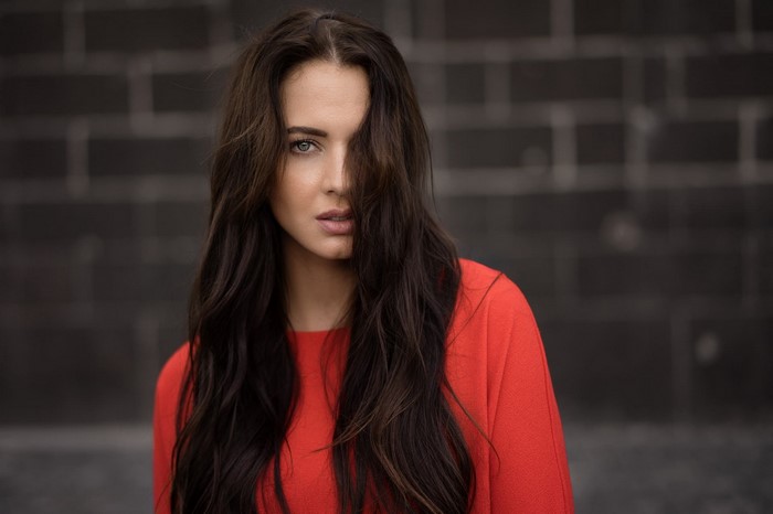 Woman with long brown hair in a red top