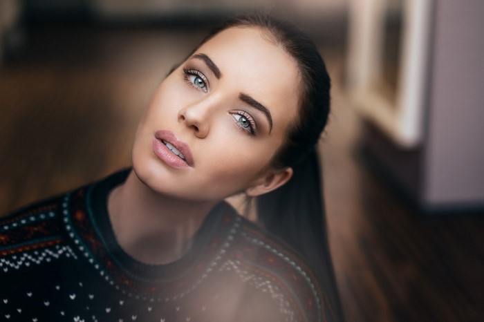 Woman with brown hair and blue eyes wearing a sweater