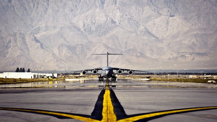 C-17 Globemaster III on an airport runway with mountains