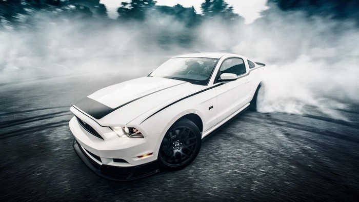 White Ford Mustang performing a burnout