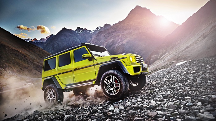 Yellow Mercedes-Benz G 500 SUV off-roading in mountains