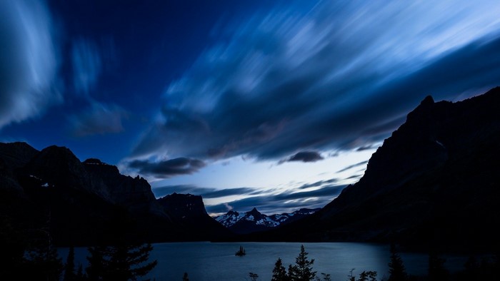 Mountains and lake at dusk with streaking clouds