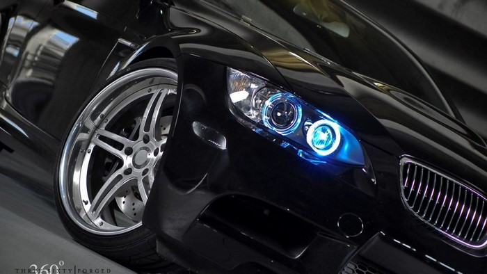 Black BMW M6 with custom rims and blue headlights