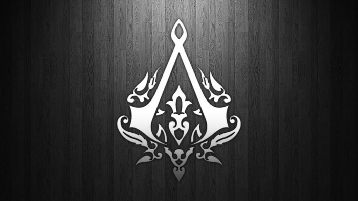 Assassin's Creed logo on a dark wooden background