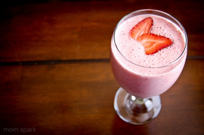 Strawberry smoothie in a glass with strawberries