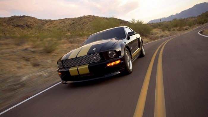 Black Ford Mustang GT with Gold Stripes on Desert Road