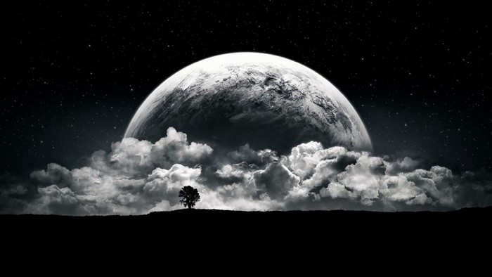 Planet and clouds over silhouetted landscape