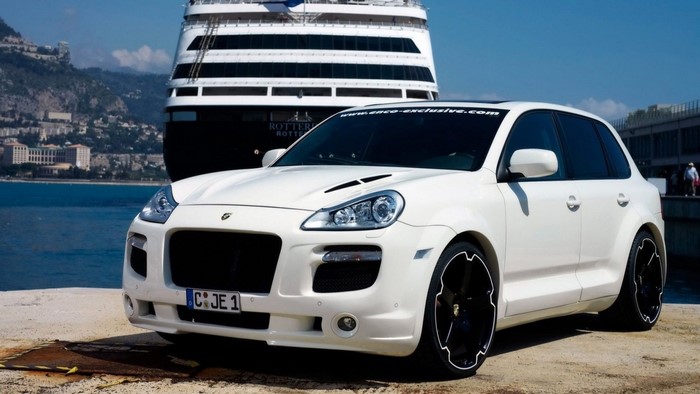 White Porsche Cayenne parked by a cruise ship