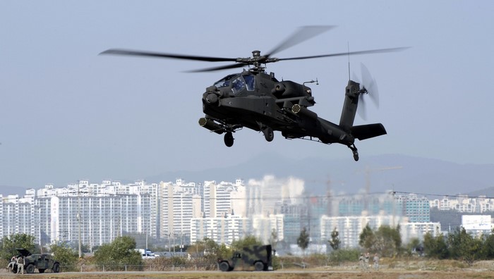AH-64 Apache helicopter in flight over city