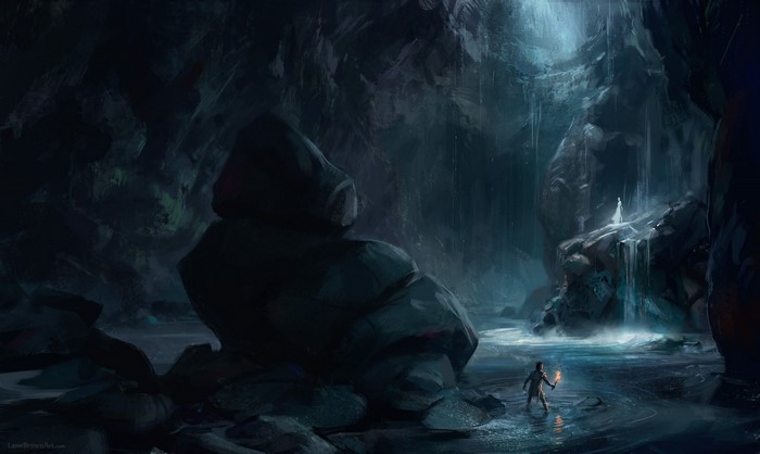 Man with torch in a dark cave with waterfall