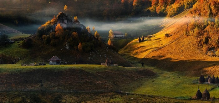Autumn valley with rolling hills and mist