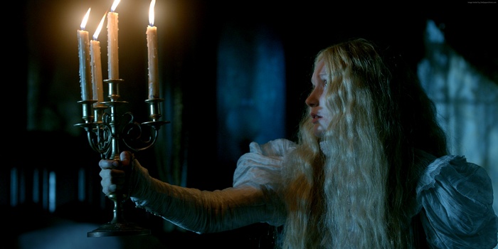 Mia Wasikowska holding a candelabra in Crimson Peak