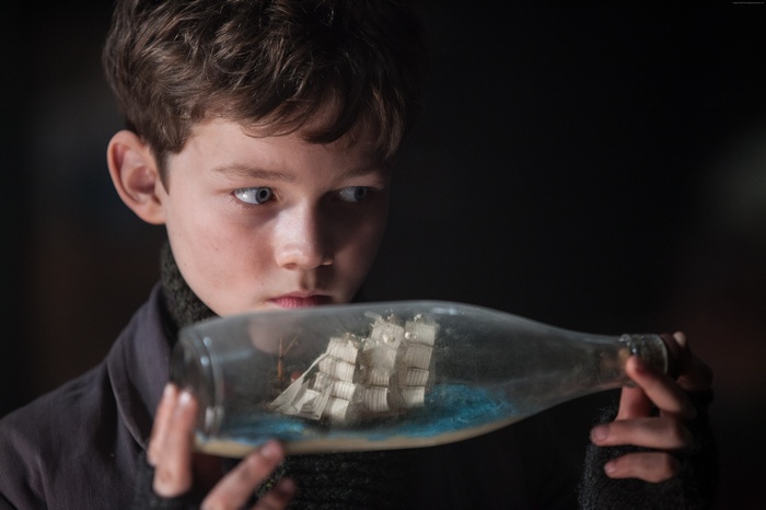 Peter Pan holding a ship in a bottle