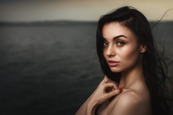 Woman with long black hair by the water