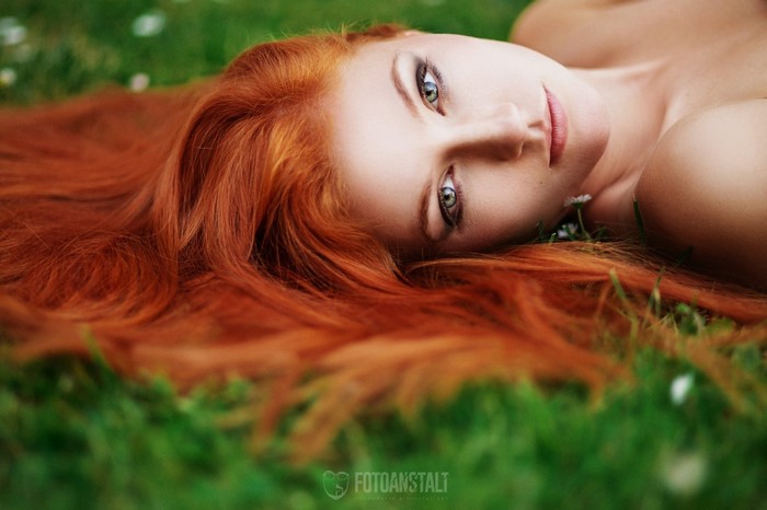 Redhead woman lying on grass
