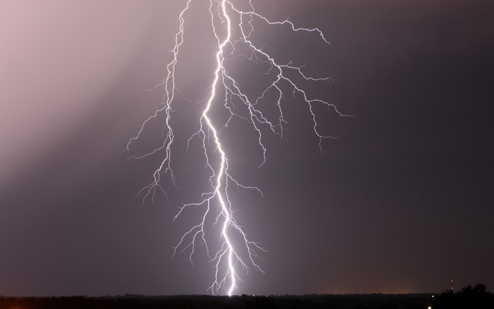 Lightning strike over a dark landscape