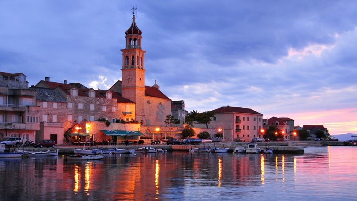 Coastal town with church tower at sunset