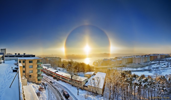 Winter cityscape with sun halo over water