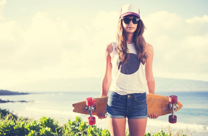 Woman with skateboard at the beach