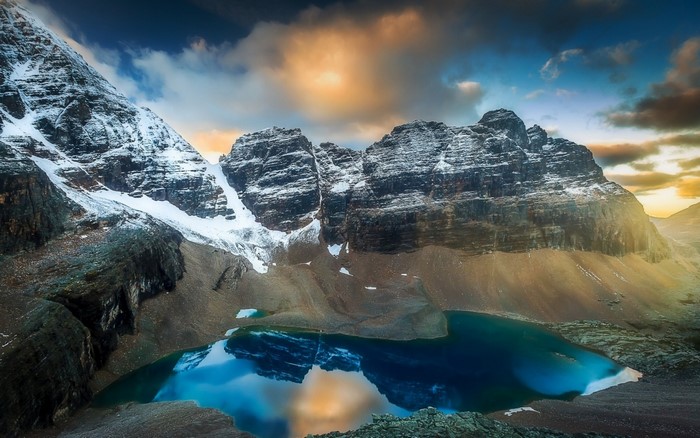 Snowy Mountains Reflecting in a Turquoise Lake at Sunset