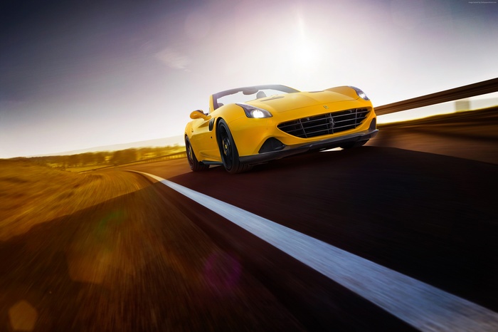 Yellow Ferrari California T driving on a road