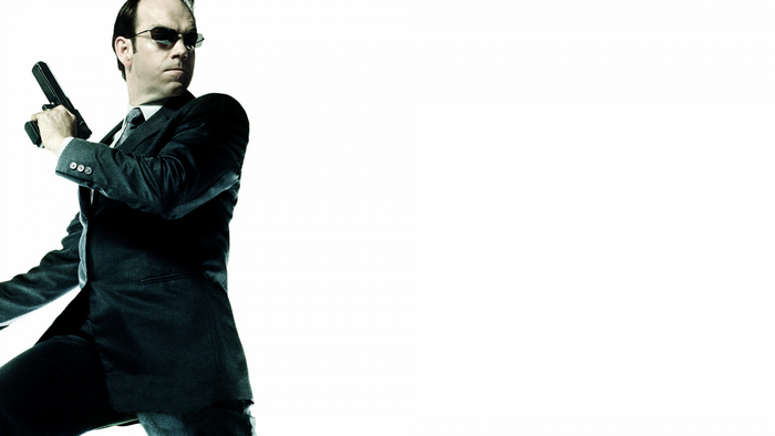 Agent Smith from The Matrix holding a gun