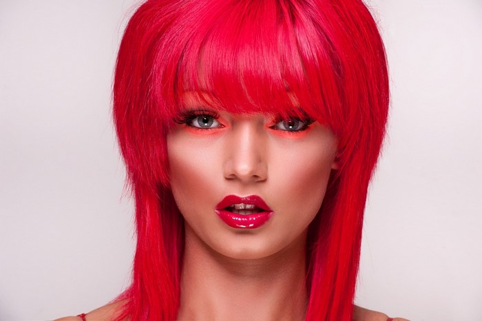 Woman with bright red wig and makeup