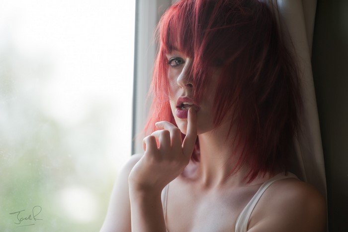 Woman with red hair by the window