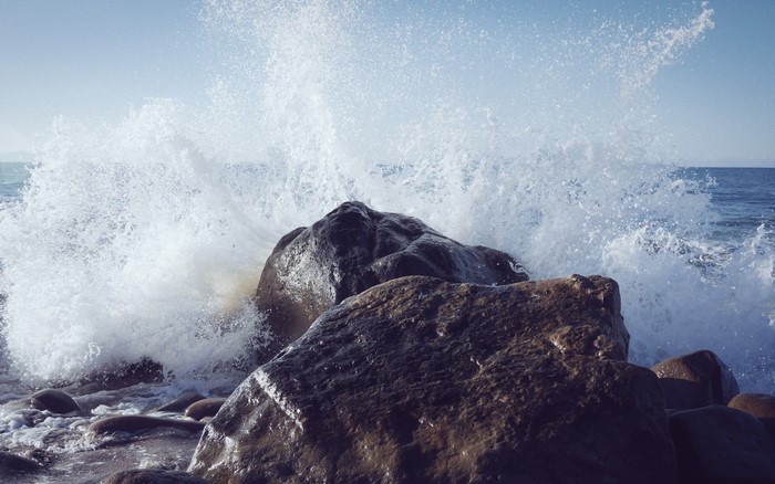 Wave crashing on rocks at the sea shore