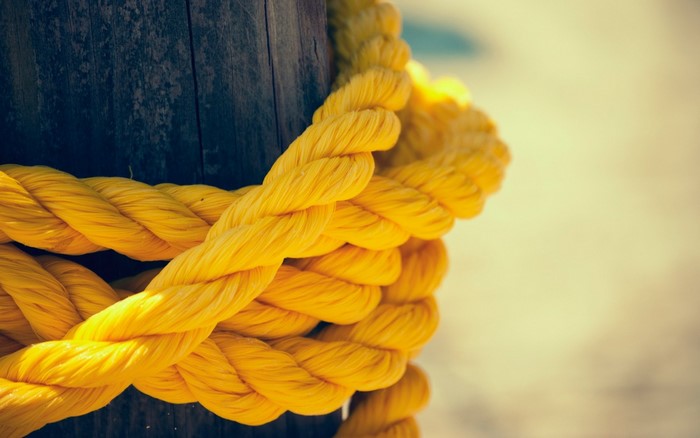 Yellow rope tied around a wooden post