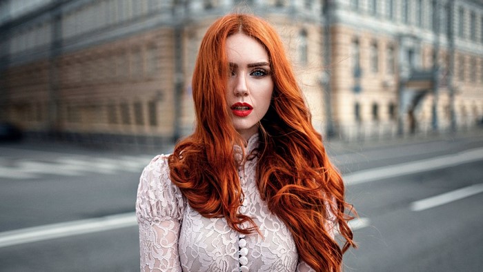 Redhead Woman with Wavy Hair in Urban Street