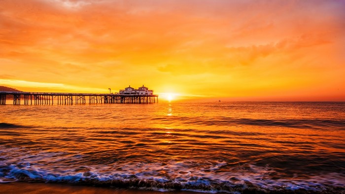 Sunset over the ocean with a pier