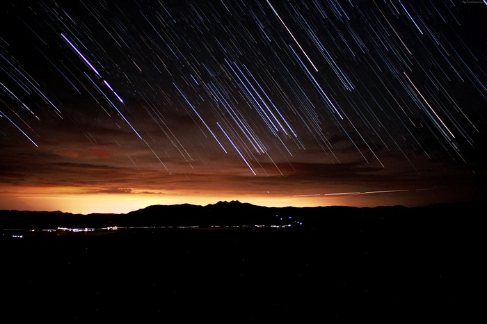 Star trails over mountains at sunset
