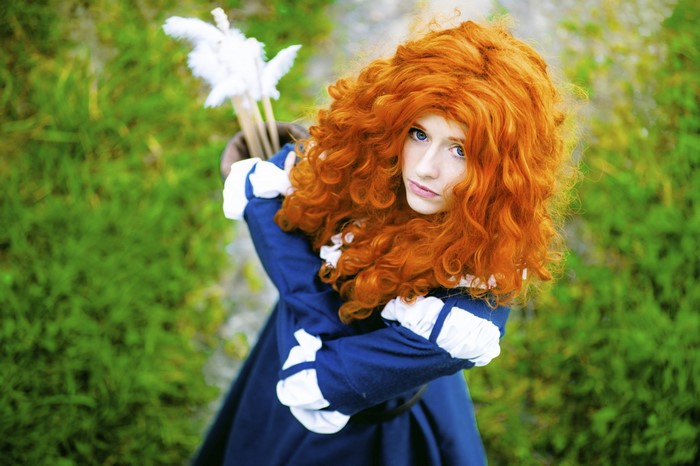 Woman in Merida cosplay with bow and arrows