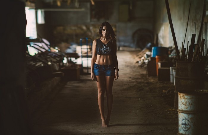 Woman in crop top and jean shorts in abandoned building