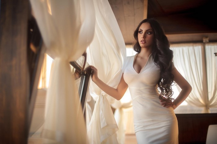 Elegant Woman in White Dress by Window