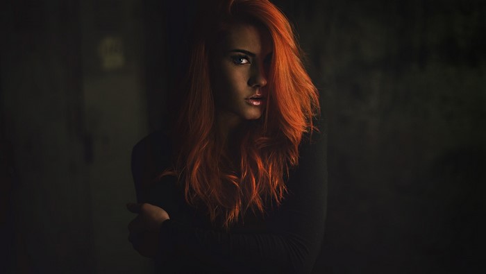 Woman with red hair in dark setting