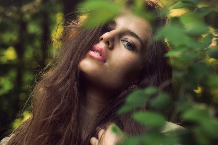 Woman with long brown hair in a forest