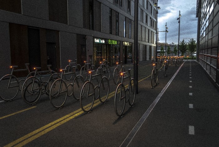 Bicycle parking area at night with modern buildings