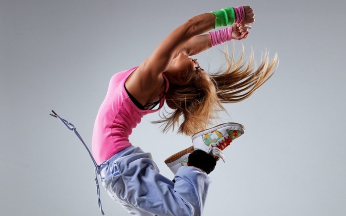Woman dancing in pink tank top and sweatpants