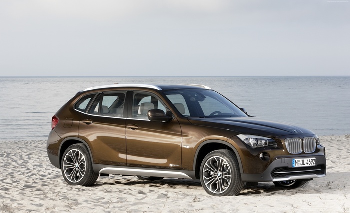 Brown BMW X1 xDrive on a sandy beach