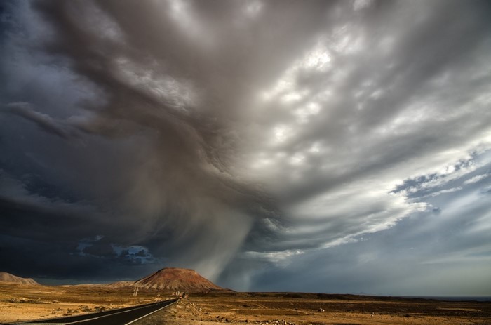 Storm clouds over a desert landscape with a road