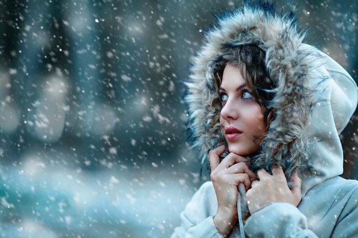 Woman in a fur-lined hood in the snow