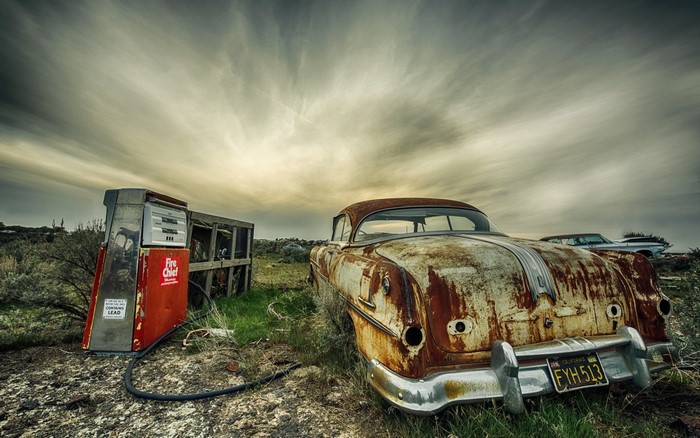 Abandoned vintage car and gas pump