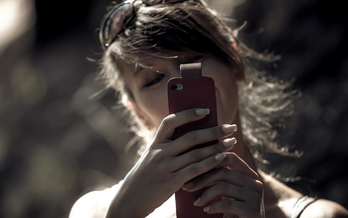 Woman taking a selfie with a red phone