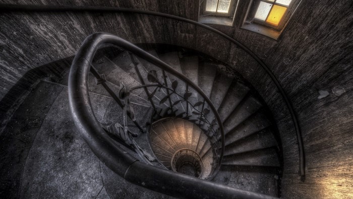 Abandoned spiral staircase with windows