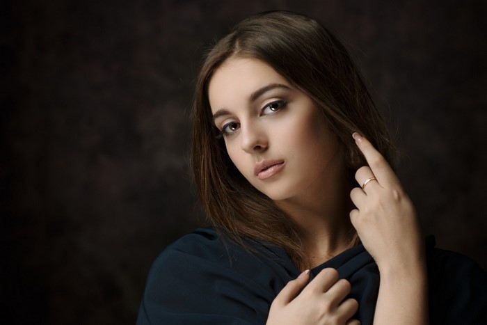 Portrait of a young woman with brown hair and blue clothing