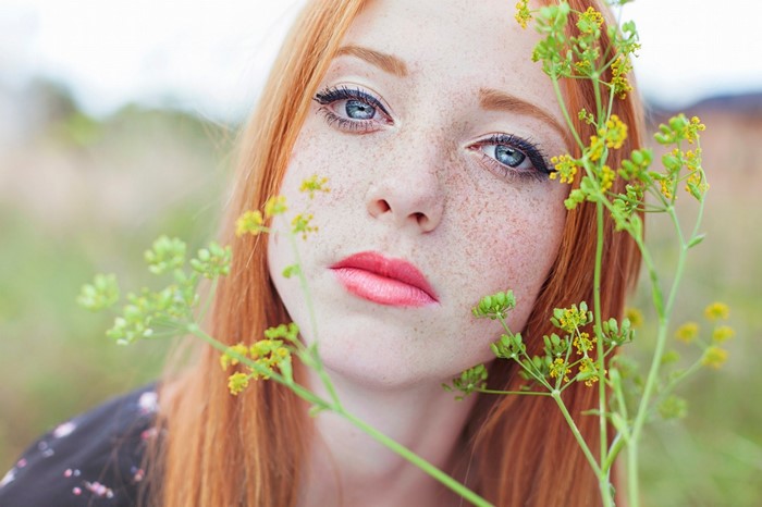 Close-up portrait of a young redhead woman with freckles
