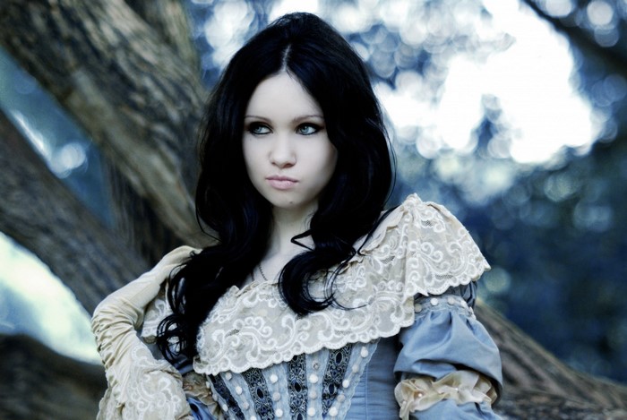Woman with dark hair in a blue and white dress